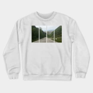 A shot on the move from behind the windshield of an electric car with alps mountains in front of it in a fresh sunny spring day. POV first person view shot on a asphalted mountain road Crewneck Sweatshirt